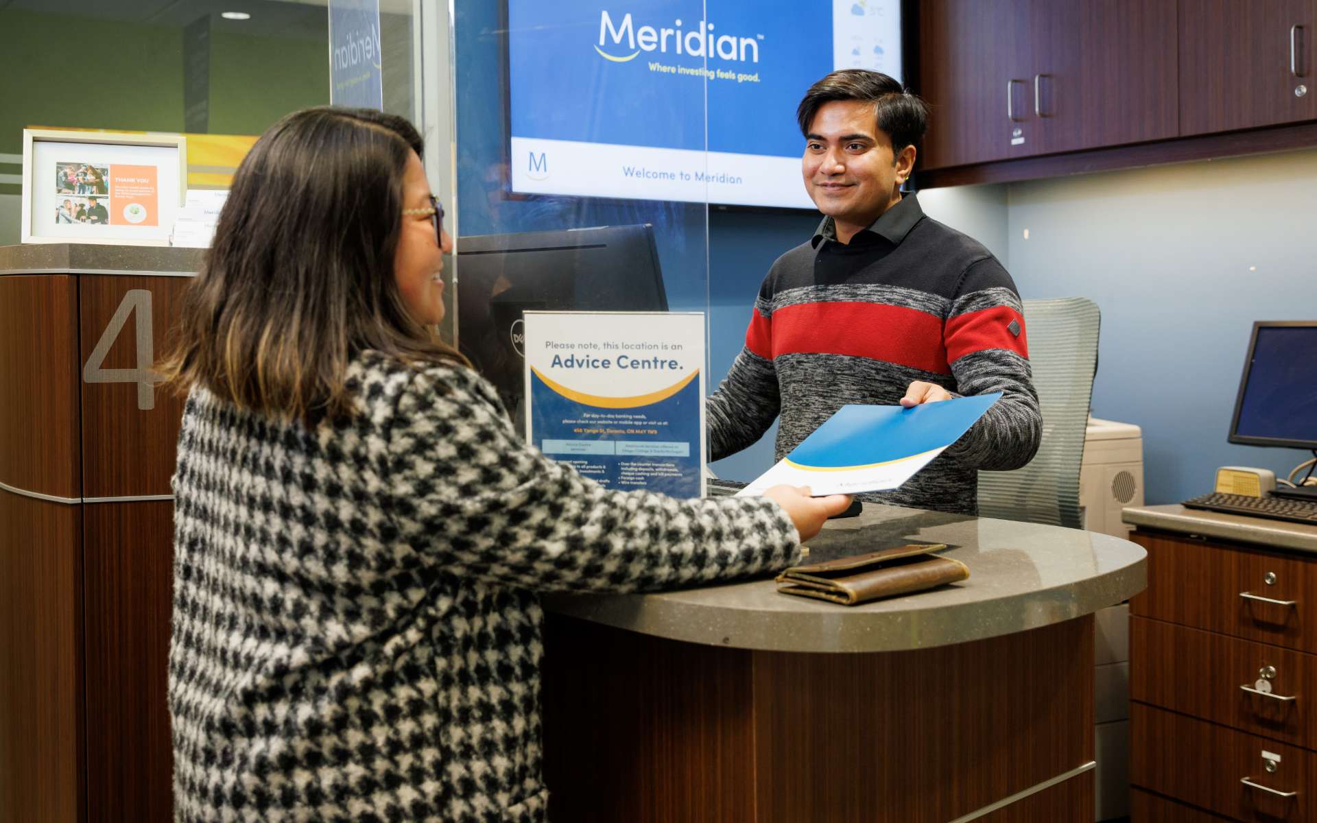 A Meridian employee greets a Member at the front desk in a branch