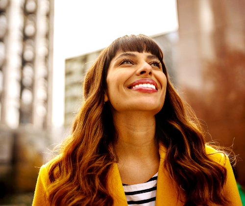 Young woman, smiling, with the city in the background