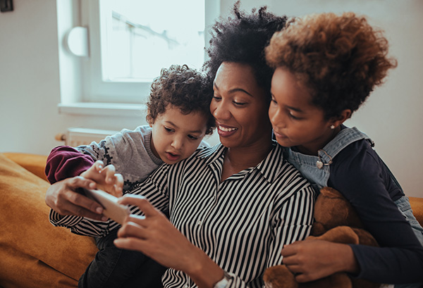 mom looking at phone with her kids