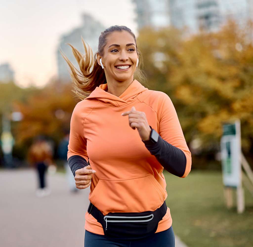 Young woman running through a city park.