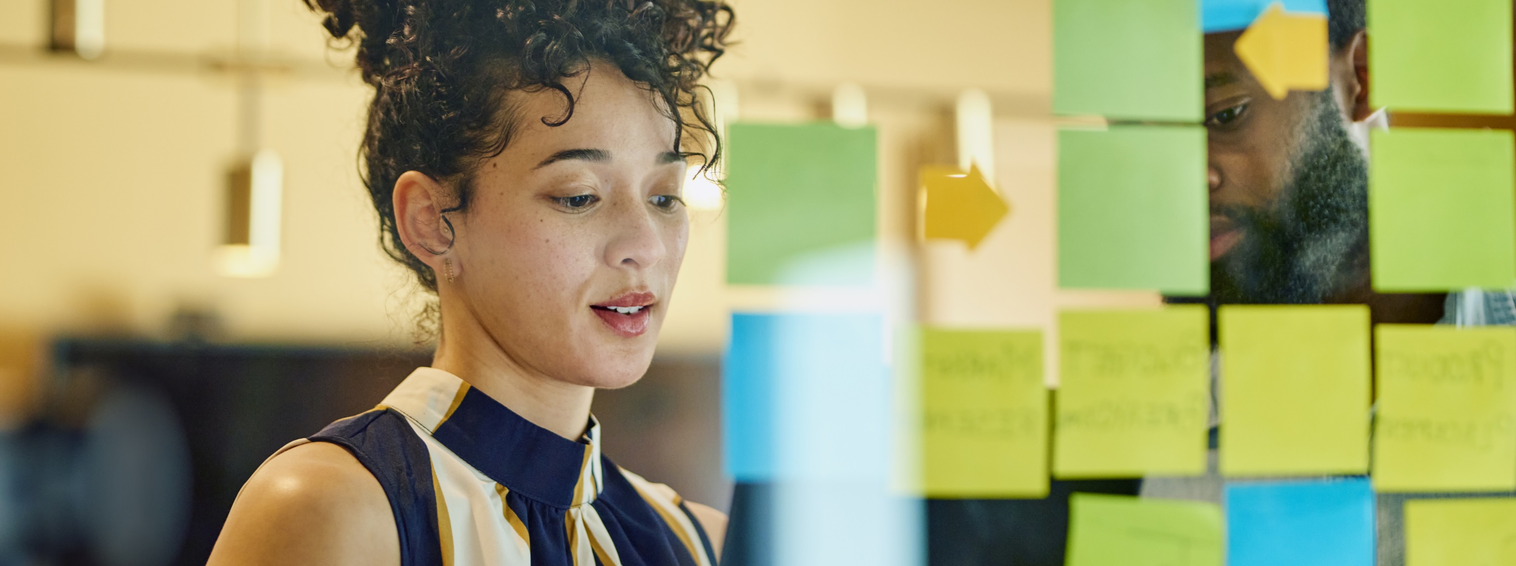 Two colleagues reviewing sticky notes during a planning session
