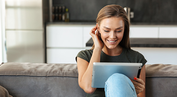 woman smiling and looking at tablet
