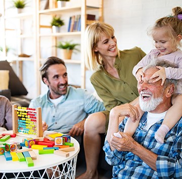 parents and grandparents playing with granddaughter