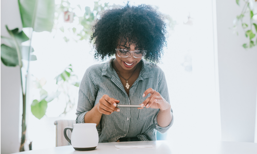 Smiling woman taking a photo of a cheque with her phone