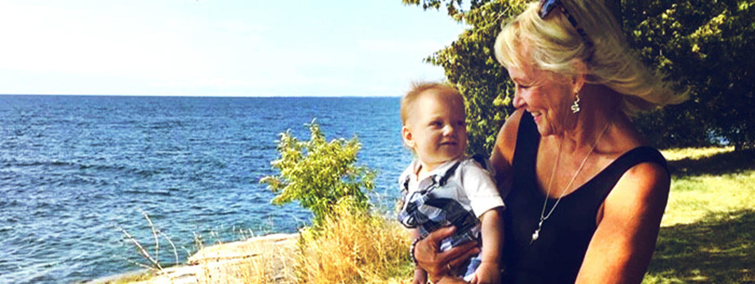 Anne, a Meridian Member, holds her grandchild and stares at him with adoration