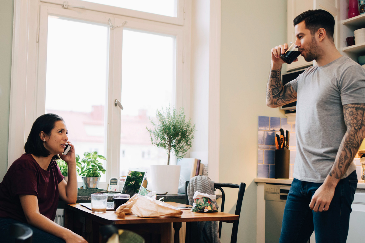 A couple are facing each other, with the woman calling to consult about something on the phone.