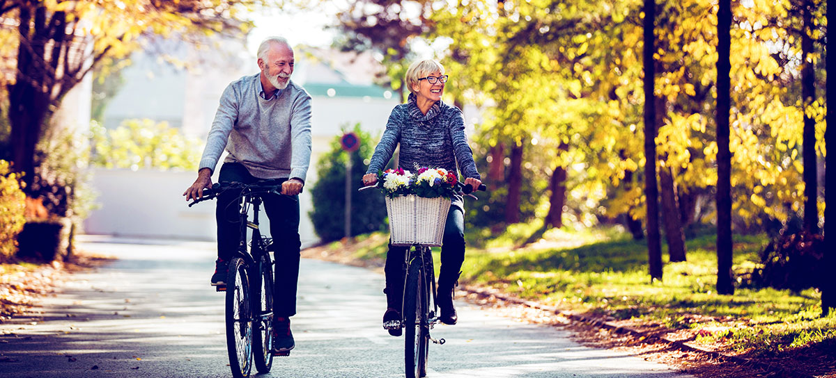 mature couple riding bikes in the fall