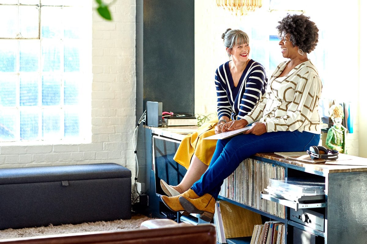 Two middle aged women laughing together at a record store