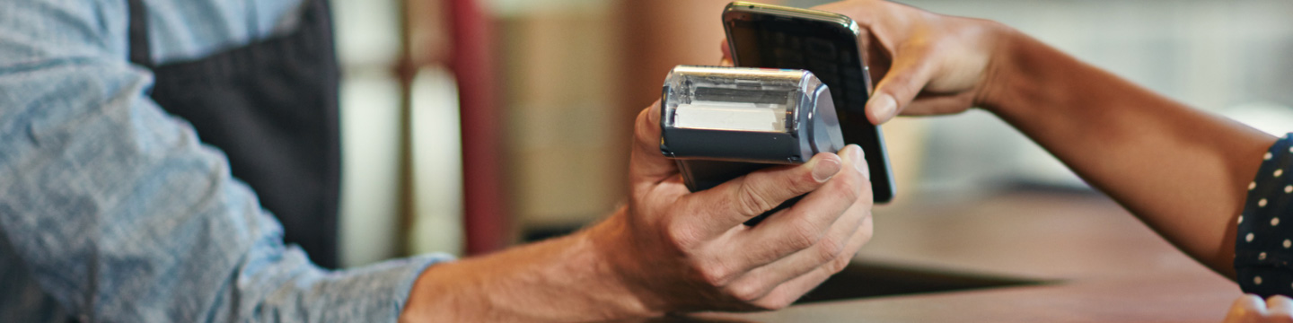 Woman using her phone at a cashier