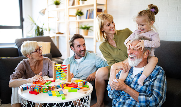 parents and grandparents playing with granddaughter
