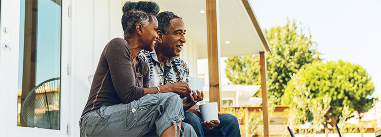 Older couple sitting on their front porch enjoying a cup of coffee