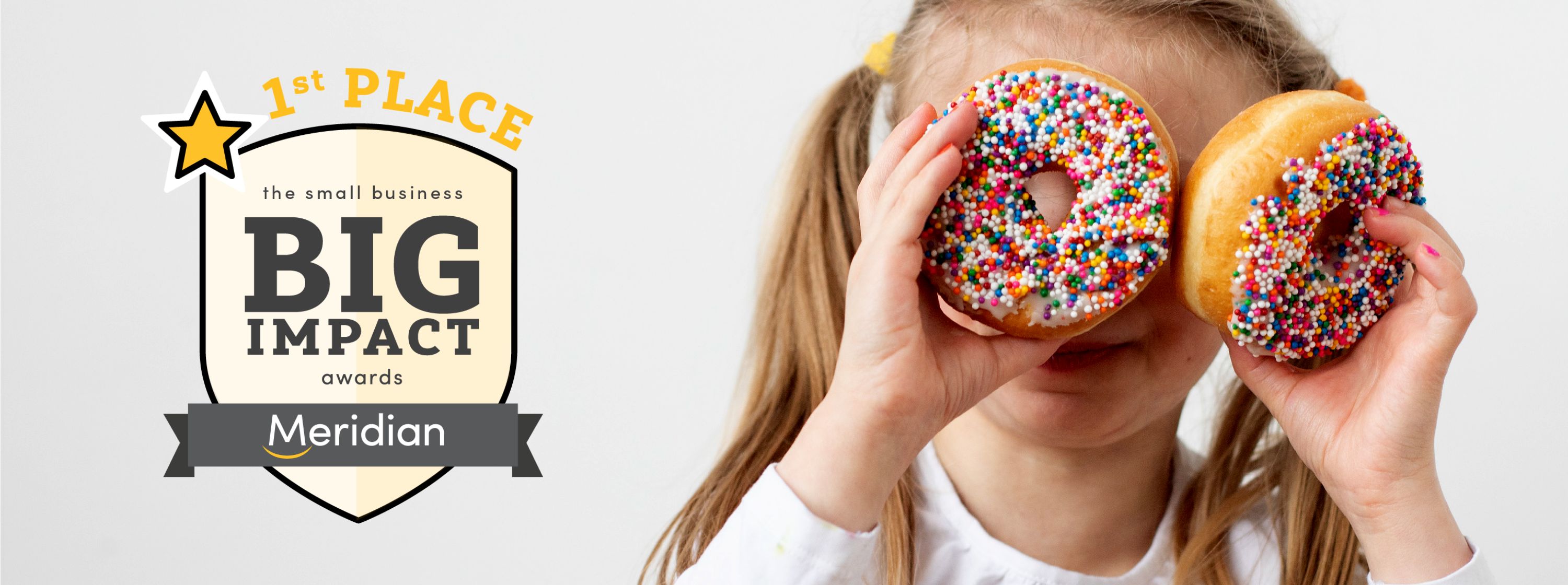 A little girl holds two donuts up to her face like eyes. Text reads First place the small business big impact awards Meridian