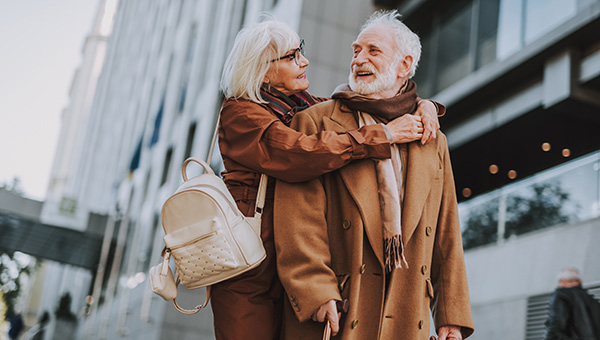 older couple hugging and walking downtown