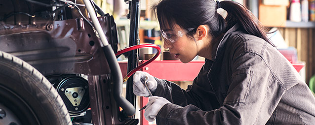 Female mechanic working on a car