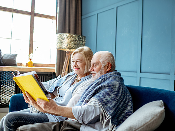older couple reading a book together at home