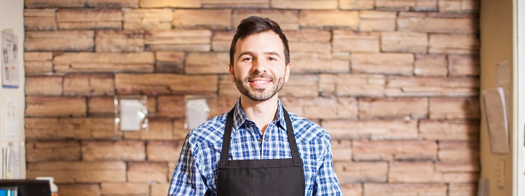 smiling male business owner wearing an apron