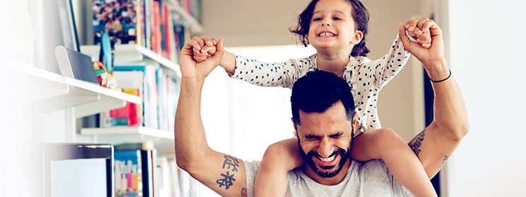 A dad with his toddler on his shoulders