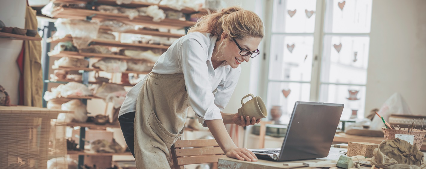 Woman at a laptop in her pottery studio