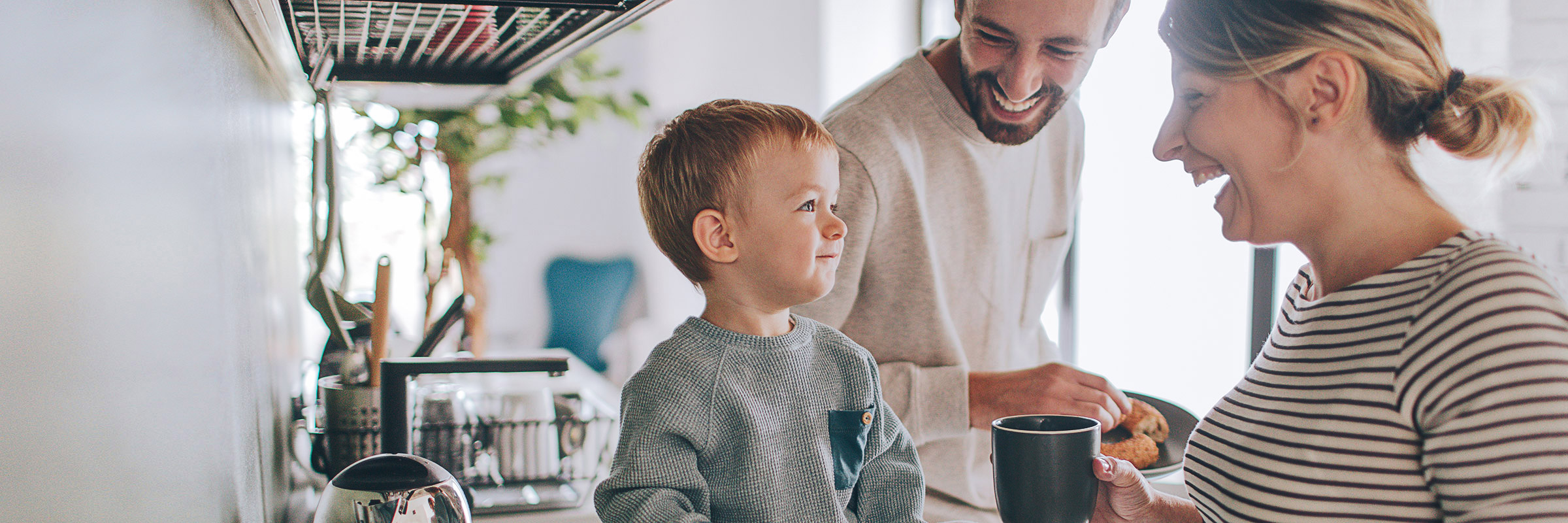 a toddler eating breakfast with his pregnant mother and father