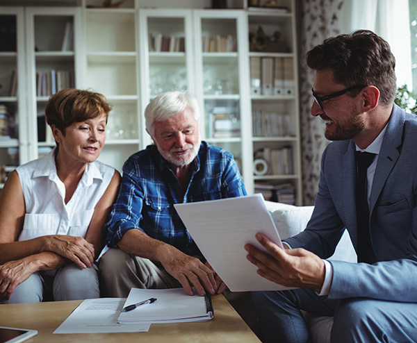 older couple sitting with their financial advisor at home