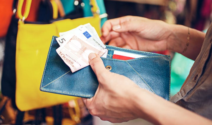 A person holding a wallet with EURO currencies