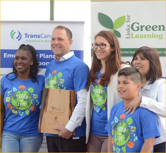 A diverse group of people wearing T-shirts that say “Trees for life” at a Links for Greener Learning event.