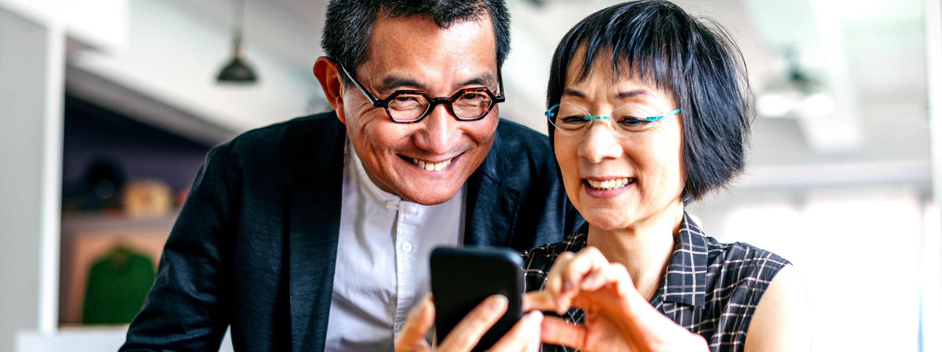 Smiling couple with tablet phone enjoying retirement