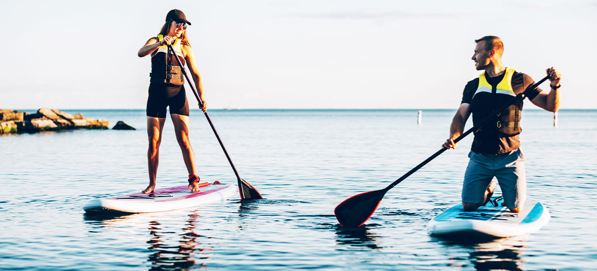 A couple paddle boarding on a lake