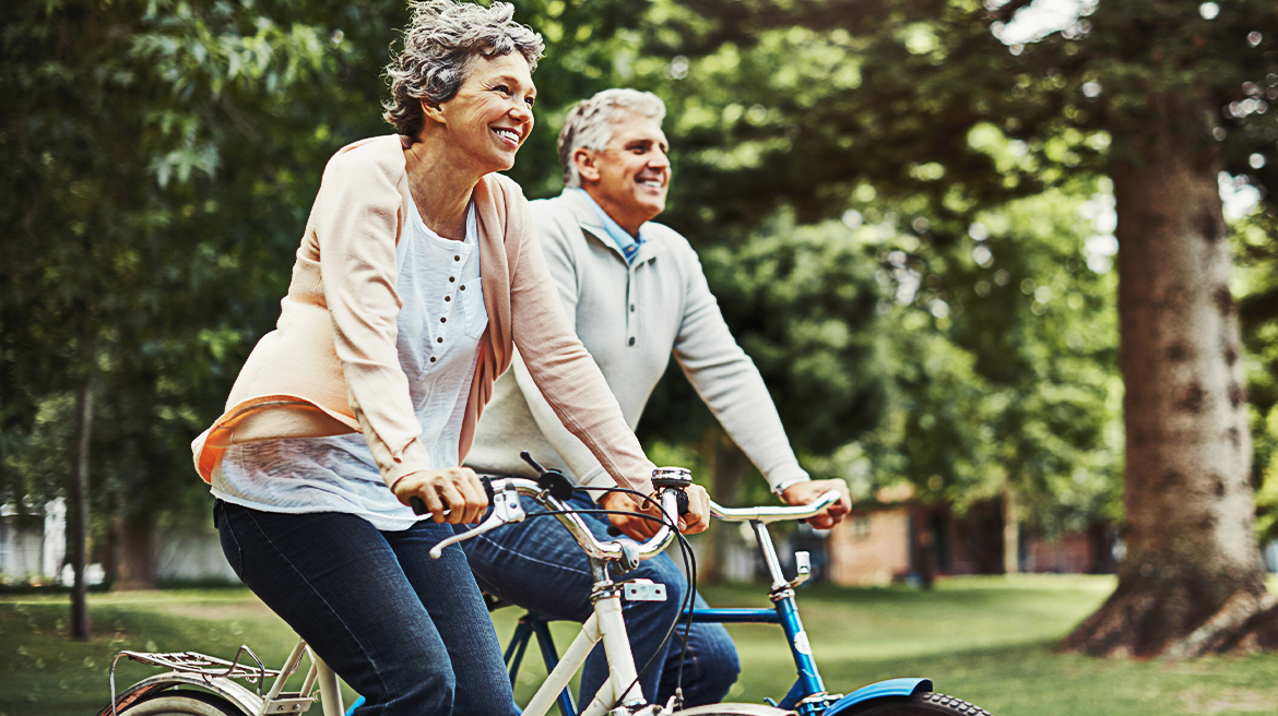 An elderly man and woman biking side by side