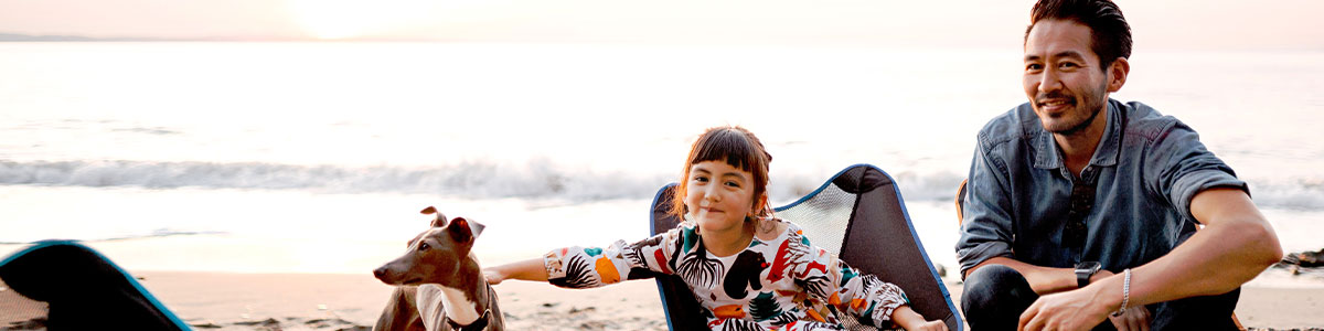 father-daughter at the beach with pet dog