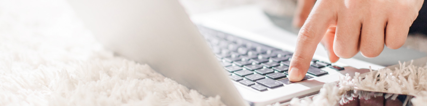 Hands typing on a laptop keyboard