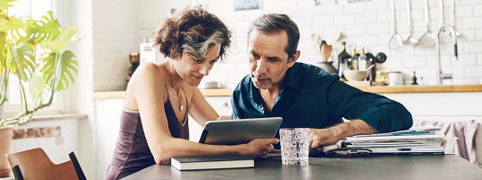 couple working on a laptop in their kitchen