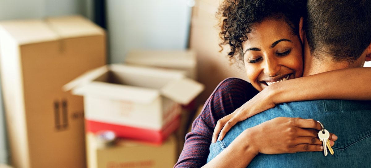 happy couple hugging holding new house keys