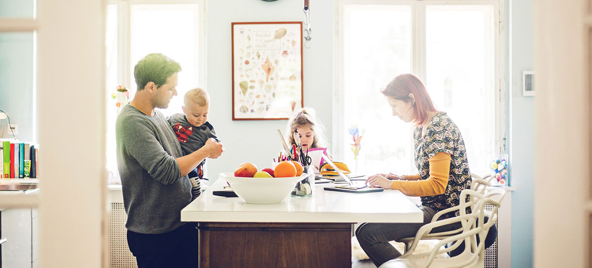 parents with two young kids sitting at kitchen island