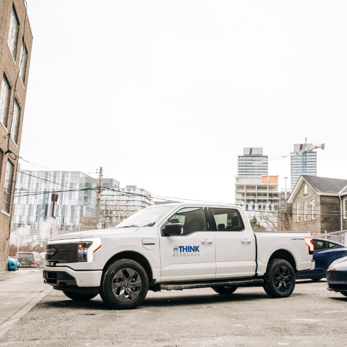 A white pick-up truck in a city parking lot