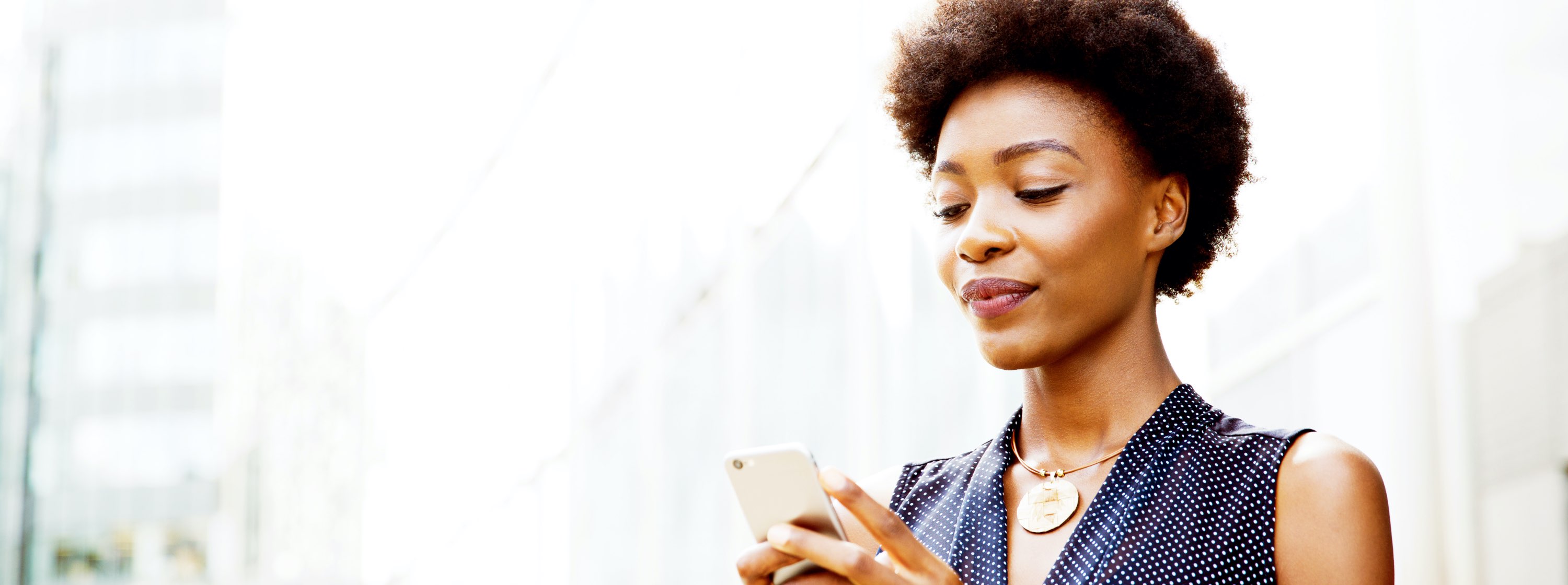 A woman looks, skeptically, at her mobile phone.